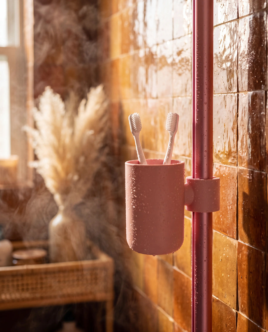 Pink Showrz cup clipped onto the shower rail